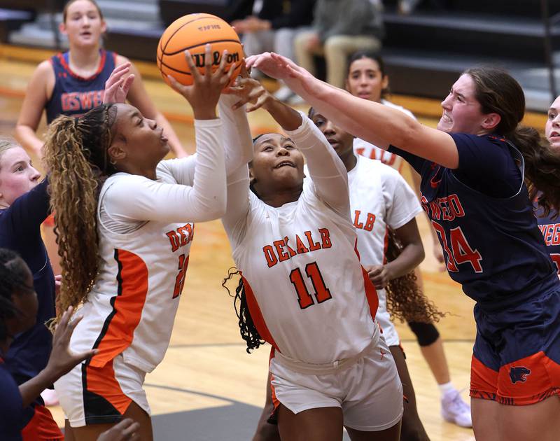 DeKalb's Zora Watts, (left) DeKalb's Johnna Patrick and Oswego's Kyla Baier (right) go after a rebound during their game Monday, Jan. 5, 2026, at DeKalb High School.