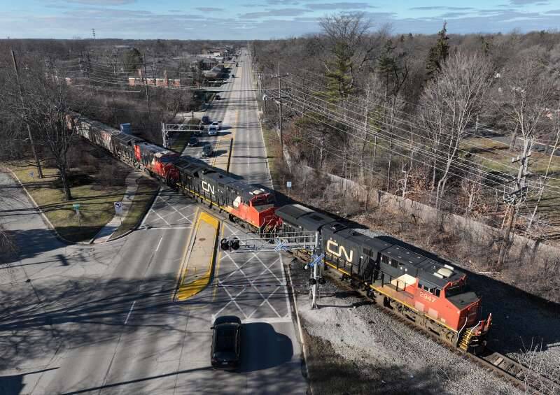 A northbound Canadian National freight train crosses Route 14 earlier this year. The village's grade separation project will create an underpass that will help drivers avoid long delays from freight trains at the crossing.