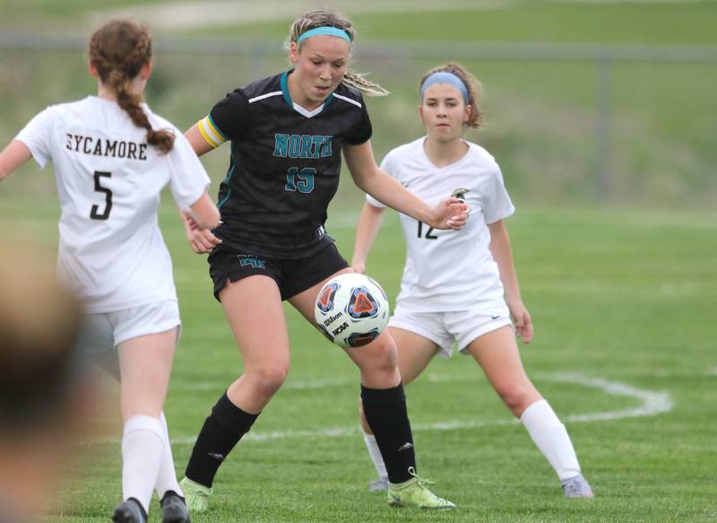 Woodstock North's Katelynn Ward receives a pass between Sycamore's Grace Parks and Hope Thomas during their IHSA Class 2A regional game Tuesday, May 17, 2022, at Burlington Central High School.