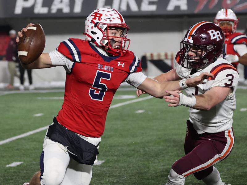 St. Rita's Steven Armbruster tries to scramble away from Brother Rice's Michael Fitzgerald Wednesday, Dec. 3, 2025, during their IHSA Class 7A state chamionship game in Huskie Stadium at Northern Illinois University in DeKalb.