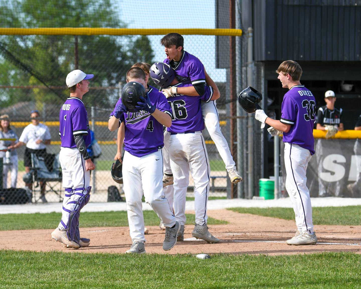 Dixon's Hayden Steinmeyer (16) lifts up teammate Gage Burdick after he hit a home run to tie the game 5-5 against Kaneland High School during a sectional playoff game held in Sycamore on Wednesday, June 1, 2022.