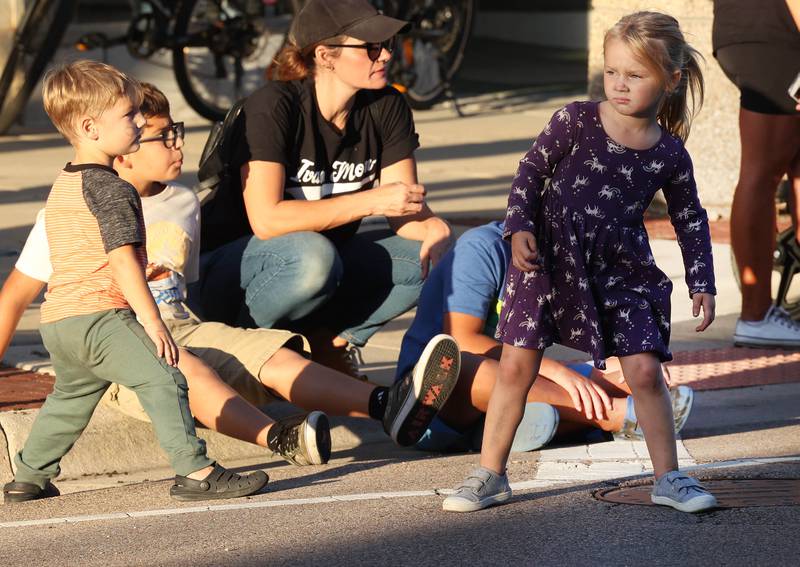 Lark Kettner, (right) 3, from Sycamore, peers down State Street in Sycamore to see if the parade is coming Wednesday, Sept. 25, 2024, during the Sycamore High School homecoming parade.