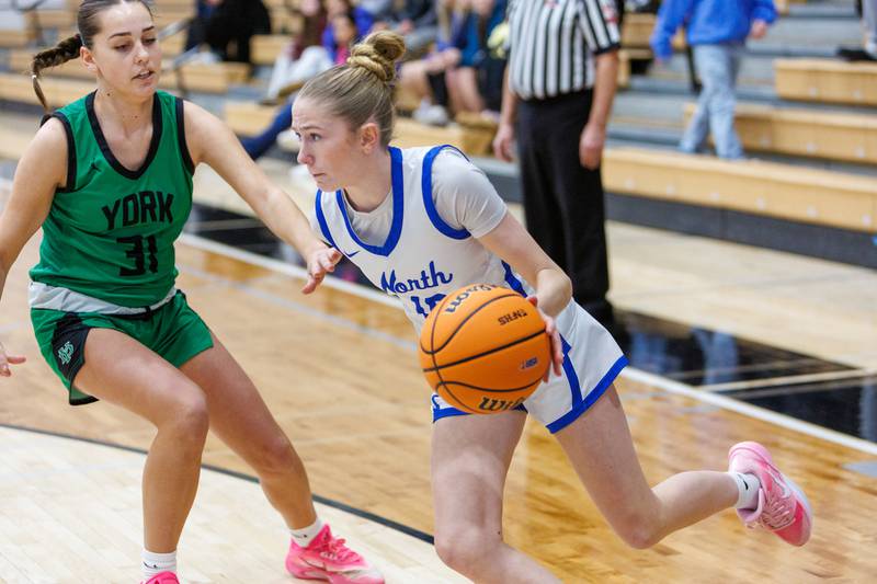 St. Charles North's Jillian Salter drives the baseline against York's Paige Byrne at the Class 4A Regional Final on Thursday, Feb.19,2026 in St. Charles.
