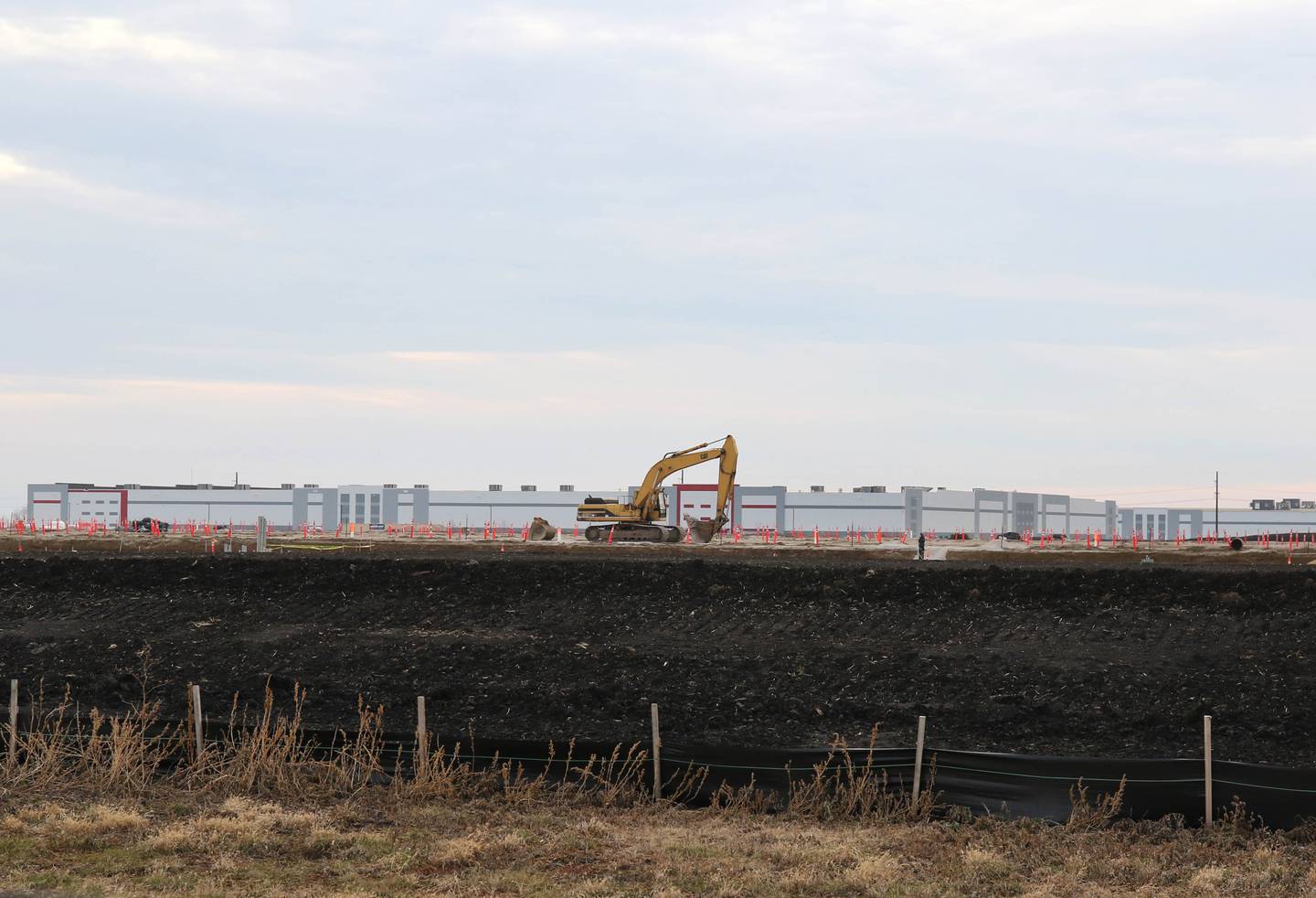 Grading and preparations for building construction are underway Tuesday, Dec. 14, 2021, on the plot of land at the corner of East Gurler Road and Crego Road in the ChicagoWest Business Center in DeKalb. Amazon recently paid $6.3M for the 59 acre parcel. The building in the background is the Ferrara Candy Company.