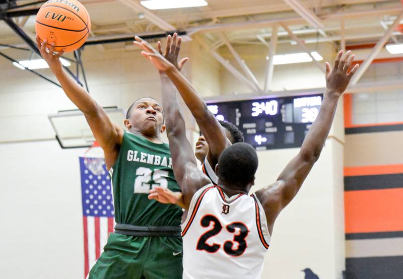 Glenbard West's Ashton Flowers (25) takes a shot over DeKalb's Davon Grant (23) during a game in DeKalb on Wednesday, Dec. 4, 2024.