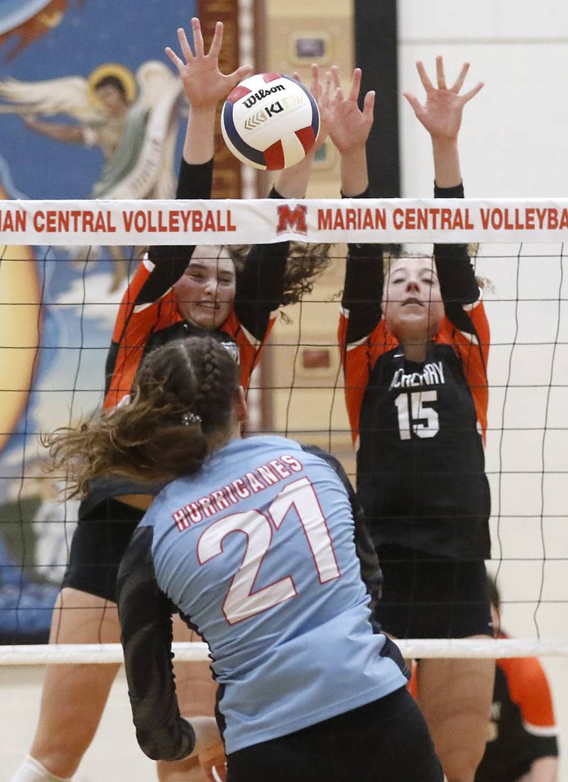 McHenry's Mollie Hobson and Sophie Zieba block the hit by Marian Central's Hadley Rogge during a nonconference volleyball match Monday, Aug. 28, 2023, at Marian Central Catholic High School.