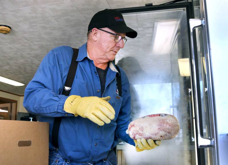 Robert Kauffman, of Kauffman Turkey Farms, stocks the refrigerator with product Monday, Nov. 6 2023, at their farm in Waterman. The Kauffman’s are retiring but plan to remain open until they sell what they have left in stock.