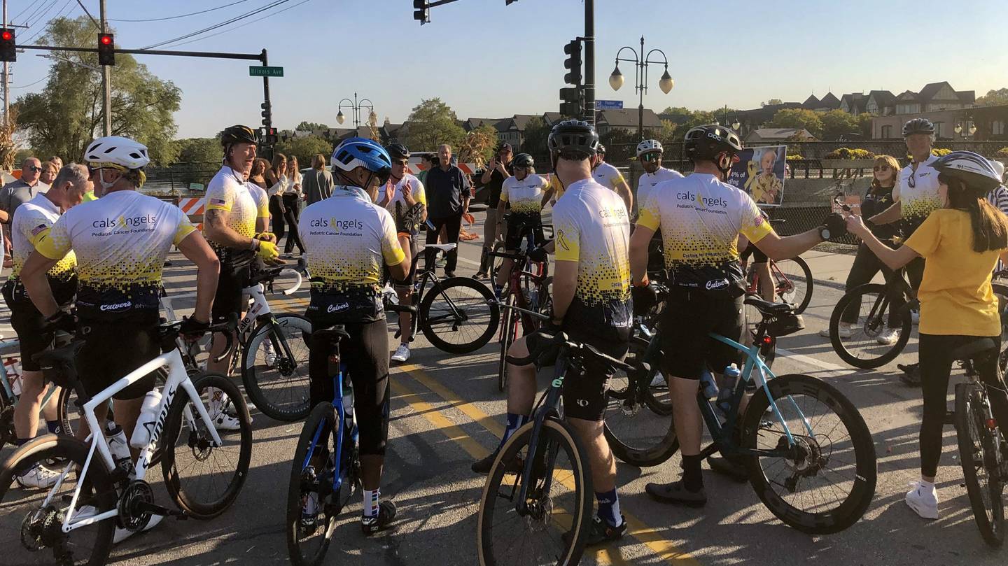 Cyclists gather at the corner of Illinois Street and Riverside Avenue in St. Charles after finishing a 475-mile charity bike ride for pediatric cancer on Oct. 10, 2024.