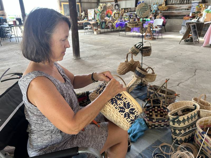 Tracy Welch of Long Grove, Iowa, bends rattan to make a basket at the Bos Brothers Historical Farm on Friday, July 25, 2025.