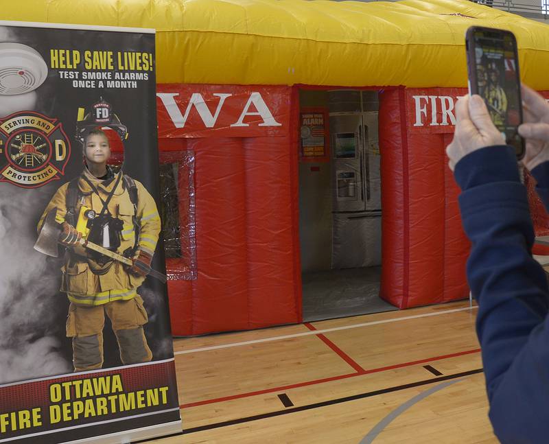 Evan Degner has his photo taken outside the Ottawa Fire Department’s Fire Safety House Saturday at the Ottawa Y during Healthy Kids Day.