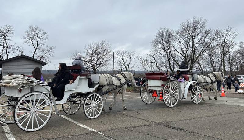 People ride in the back of a carriage during the Miracle on First Street event on Saturday, Dec. 2, 2023 in La Salle.