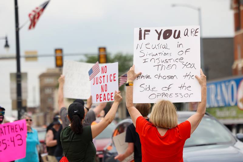 Protesters hold signs as approximately 500 people gathered at the Kankakee County Courthouse for a ‘No Kings’ rally in Kankakee on Saturday, June 14, 2025, to protest actions by President Donald Trump.