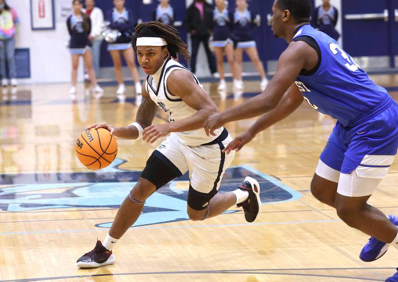 Downers Grove South's Keon Maggitt drives the lane against Proviso East's Jerry Johnson during their game Friday, Feb. 14, 2025, at Downers Grove South High School.