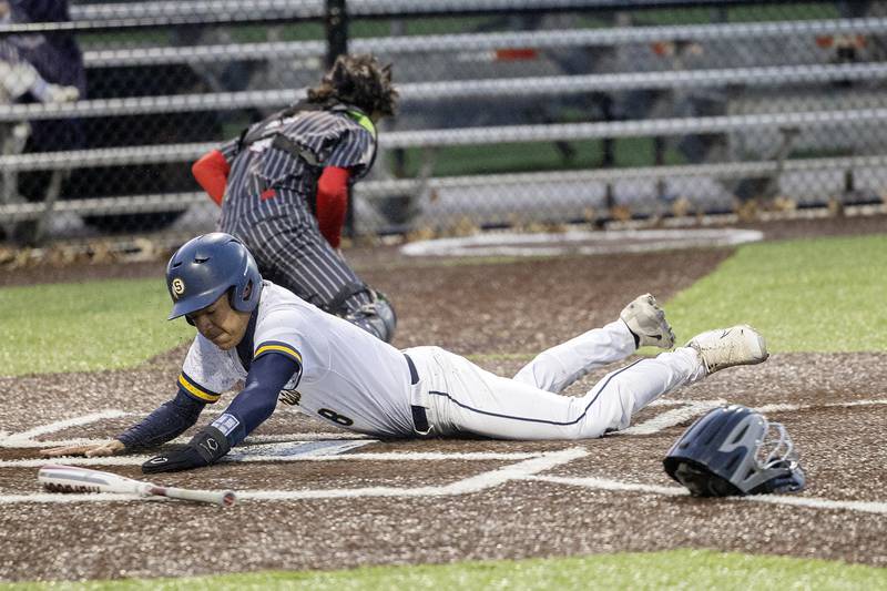 Sterling’s Tatum Allen slides in safe at home plate after a double by teammate Drew Nettleton against Hall Wednesday, April 17, 2024 at Gartner Park in Sterling.