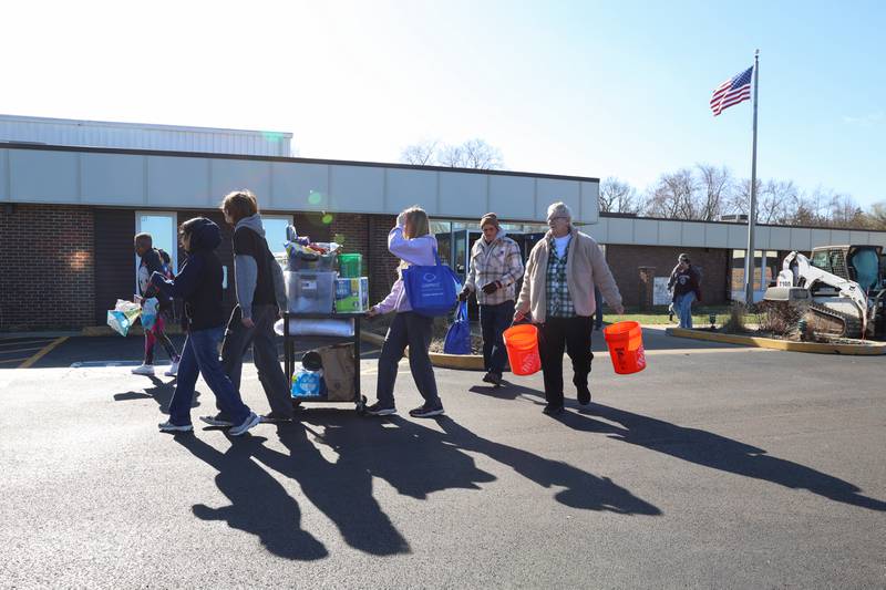 Volunteers help local residents bring supplies to their vehicles at Grace Christian Academy on Thursday, March 12, 2026, following the EF-3 tornado that tore through Kankakee County on March 10. The school, which is on the outskirts of Aroma Township along Waldron Road, canceled classes in order to become a supply and meal hub for those impacted by the storm.