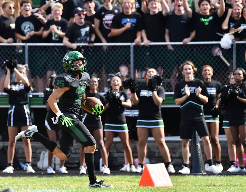 Glenbard West's Mason Ellens (15) races down the sideline for a touchdown on a late fourth quarter kickoff return to tie the game against Marist on Aug. 26, 2023 at Glenbard West High School in Glen Ellyn.