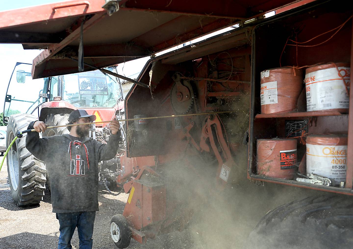 Farmer Bryon Kelly cleans his baler Friday, June 10, 2022, after baling hay on his farm near Richmond. The rising cost of nitrate and fuels is raising farmers' operational costs.