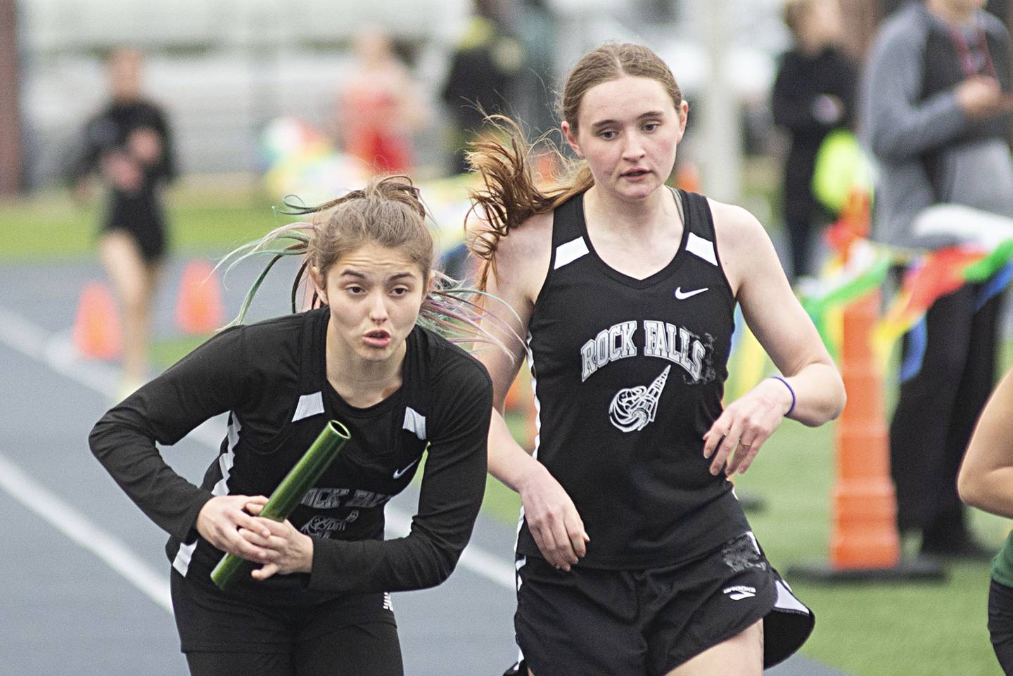 Rock Falls' Hana Ford takes the baton from Tayli Hultin in the 4x200 Friday, April 29, 2022 at the Sterling Night Relays.