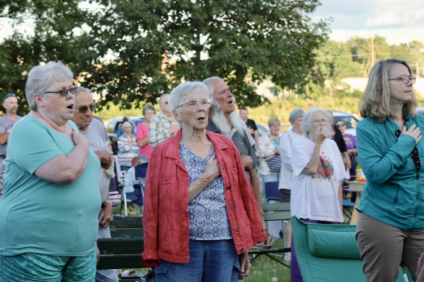 The crowd stands and sings the national anthem while it is played by the Dixon Municipal Band on Thursday at Page Park. The final performance of the Summer Sounds series will be 7:30 p.m. Aug. 4.