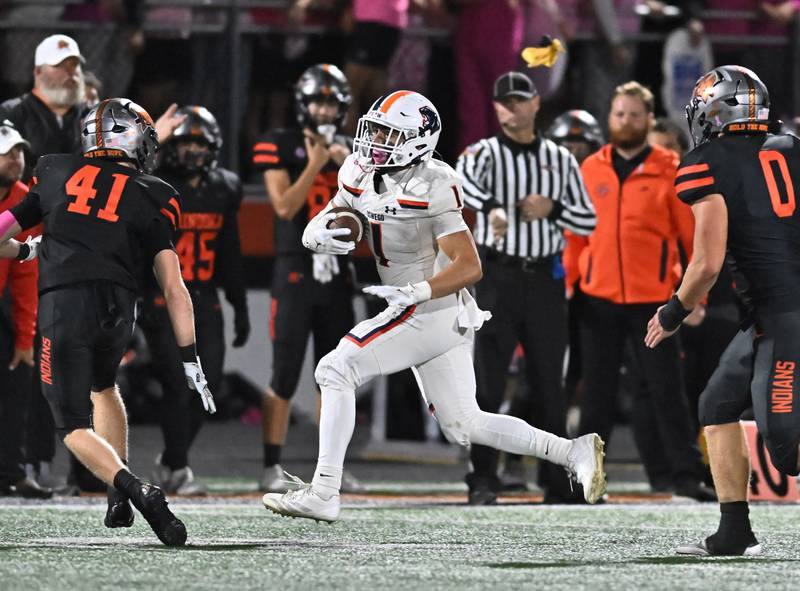 Oswego's Teddy (Theodore) Manikas (1) gains big yardage after a catch during the conference game against Minooka on Friday, OCT. 10, 2025, at Minooka.