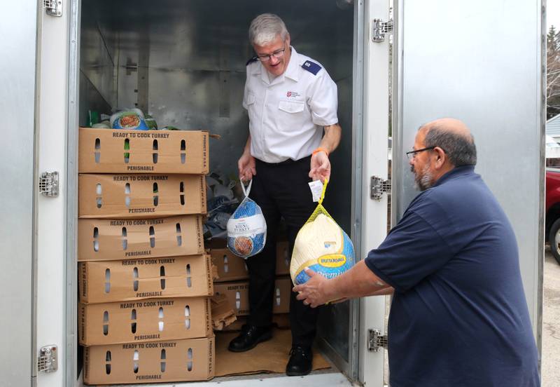 Walt Staats, (right) assistant food pantry coordinator hands turkeys to Jim Spencer, corps officer and administrator for the DeKalb Salvation Army, Friday, Nov. 22, 2024, during the Let’s Talk Turkey food drive at their facility in DeKalb. The campaign, in association with WLBK, accepted turkeys, hams and monetary donations for Thanksgiving meals.