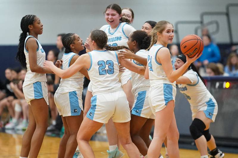 Downers Grove South players celebrate after defeating Oswego East in a 4A Oswego East Regional semifinal girls basketball game at Oswego East High School on Monday, Feb 12, 2024.
