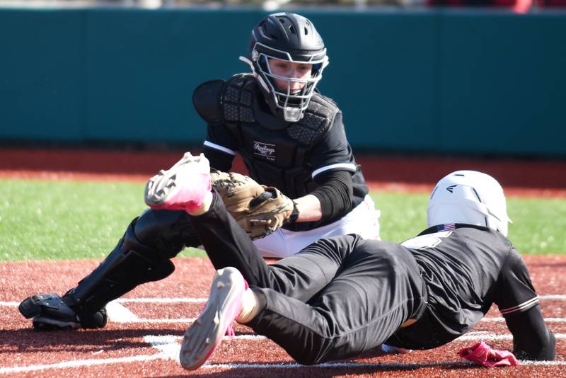 Bradley-Bourbonnais' Cody Youngblood, top, looks to tag Bishop McNamara's Gavin Jones out at home plate during a game at 315 Sports Park in Bradley Saturday, March 28, 2026.