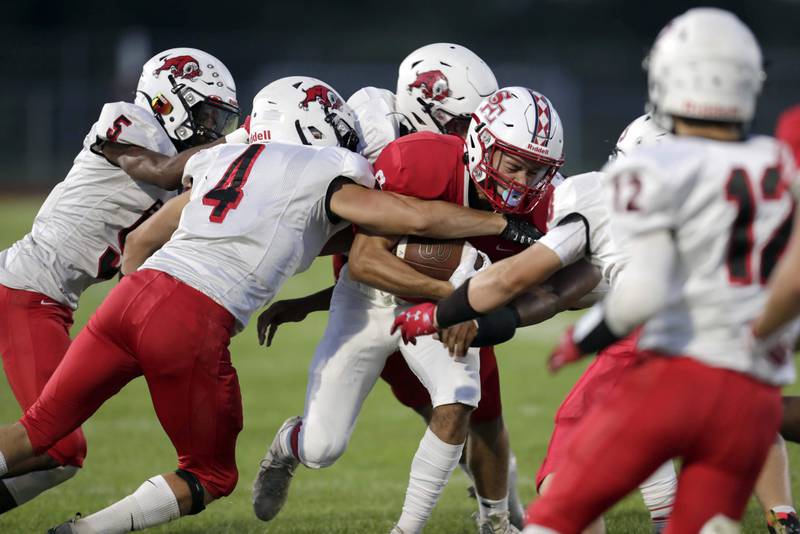 Brian Hill/bhill@dailyherald.com
South Elgin's Mason Montgomery (8) is wrapped up by a host of Glenbard East players Friday September 2, 2022 in South Elgin.