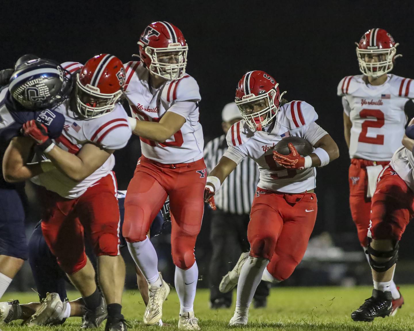 Yorkville's T.J. Harland (5) follows his blockers on a run up the middle during football game between Yorkville at Oswego East Friday, Oct 10, 2025 in Oswego.