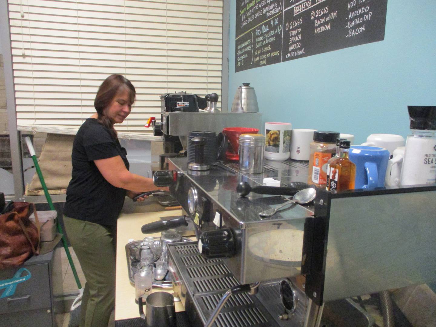 Tammy Duckworth prepares coffee while the Book and Bean Cafe at the Joliet Public Library Black Road Branch was filled with customers on Saturday afternoon. Dec. 2, 2023.
