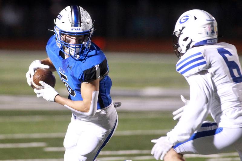 St. Charles North’s Anthony Taormina runs the ball past Geneva’s Rocco Lampiasi (right) during a game in St. Charles on Friday, Oct. 20, 2023.