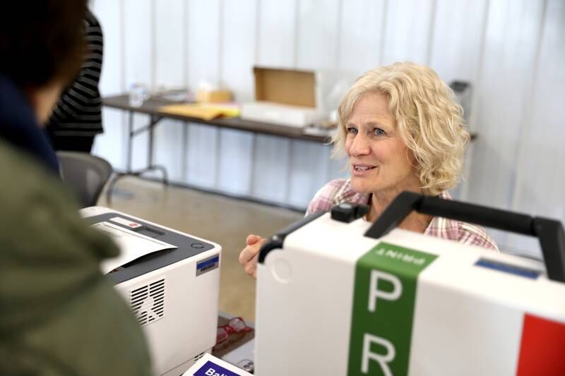 Election Judge Jodie Cleveland assists a voter in the 2024 general primary election at the DuPage County Fairgrounds in Wheaton on Tuesday, March 19, 2024.