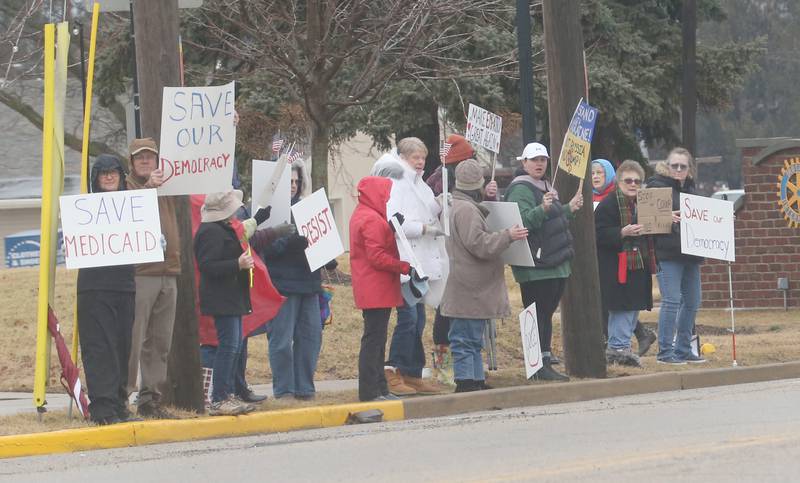 Dozens of citizens gather during a March 4 Democracy on Tuesday, March 4, 2025 at Rotary Park in Princeton. Participants brought signs to feature issues of concern for the county, state and country. The event was sponsored by concerned citizens of Bureau County.