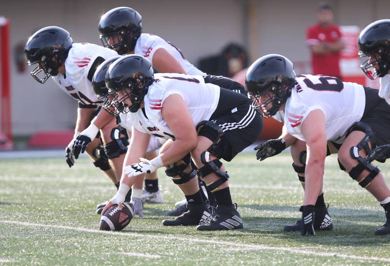 The Northern Illinois Huskies offensive line gets ready to snap the ball during the teams first practice of the season Wednesday, Aug. 2, 2023, at Huskie Stadium in DeKalb.