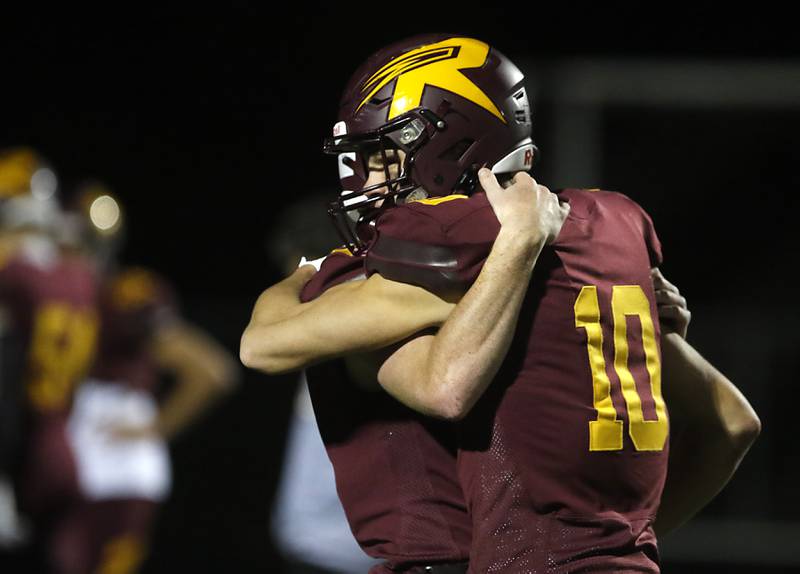 Richmond-Burton's Max Loveall (right) is huged by quarterback JT Groh after Richmond-Burton lost to St. Viator in a IHSA Class 4A first round playoff football game Friday, Oct. 27, 2023, at Richmond-Burton High School in Richmond.