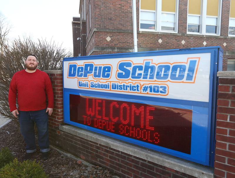DePue music teacher Tom Miller poses next to DePue School on Thursday, March 31, 2022, in DePue.