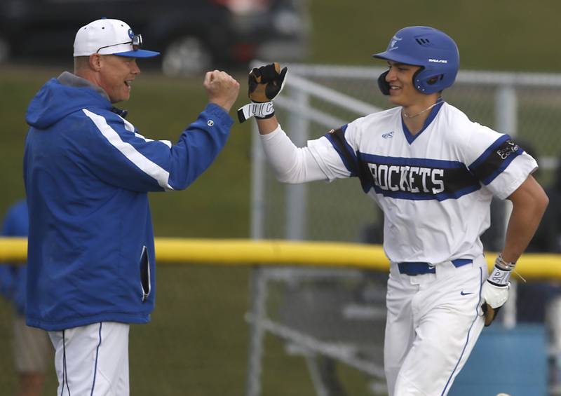 Burlington Central's Elliott Alicea celebrates his home run with coach Kyle Nelson during a Fox Valley Conference baseball game against Crystal Lake South on Friday, April 12, 2024, at Burlington Central High School.