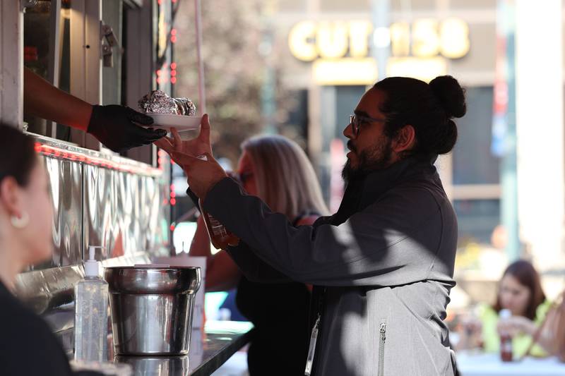 Juan Leon gets his order from the Super Mercado food truck at Salsa Fest on Friday, June 9, 2023 in Downtown Joliet.