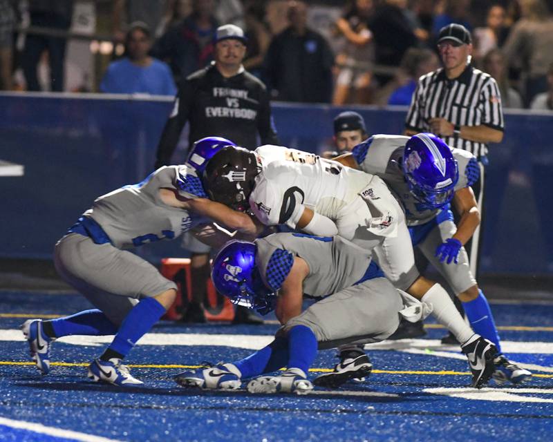 A pack of St. Francis defenders tackle Joliet Catholic Academy’s Andres Munoz, center, during the second quarter that resulted in a fumble and recovered by St. Francis held on Friday Sep. 22, 2023, held at St. Francis High School in Wheaton.