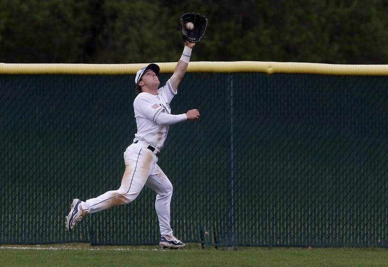 Cary-Grove's Hayden Dieschbourg chases down a fly ball during a Fox Valley Conference baseball game against Jacobs on Wednesday, April 17, 2024, at Cary-Grove High School. The game was stopped for darkness after the 9th inning with the score tied 6-6.