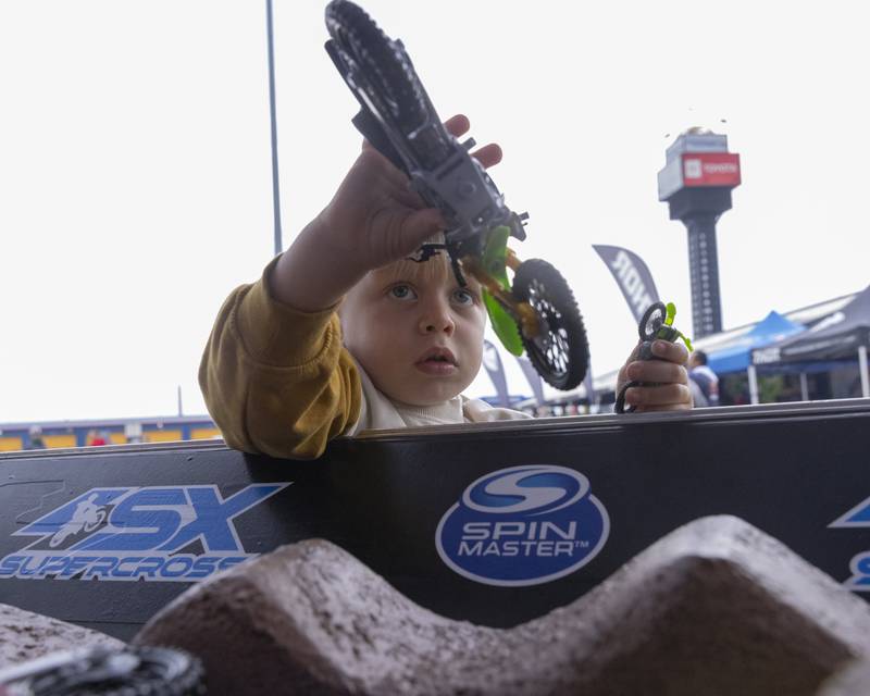Harrison Miller plays with a toy dirt bike at one of the vendors stands prior to the start of the Super Motocross Finals at Chicagoland Speedway on September 16, 2023.