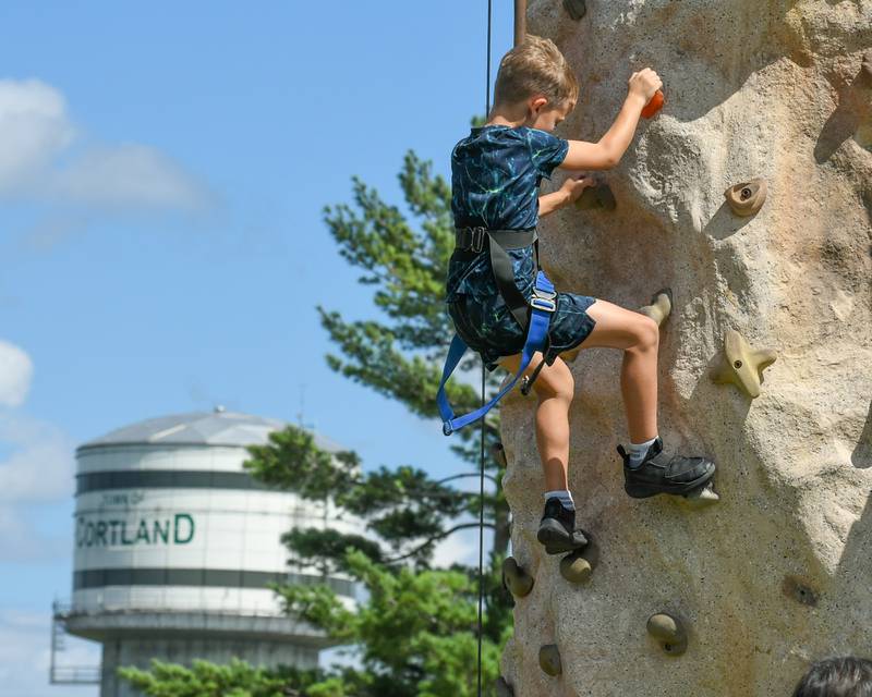 Brayden Marozik, 8, of Sycamore climbs a rock wall during Cortland Summerfest held at Cortland Community Park on Saturday, Aug. 10, 2024.