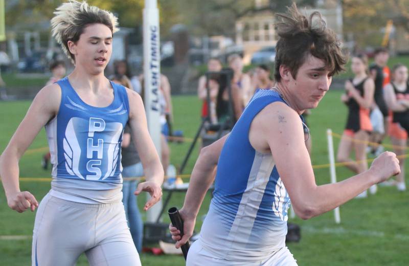 Princeton's Common Green  hands teammate Beckett Funderberg the baton in the 4x200 meter relay during the Ferris Invitational on Monday, April 15, 2024 at Princeton High School.