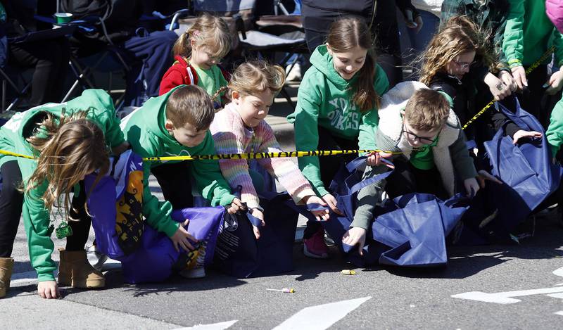 Children scramble to pick up candy during the annual St. Patrick’s Day Parade Saturday, March 8, 2025 in Elmhurst Ill.