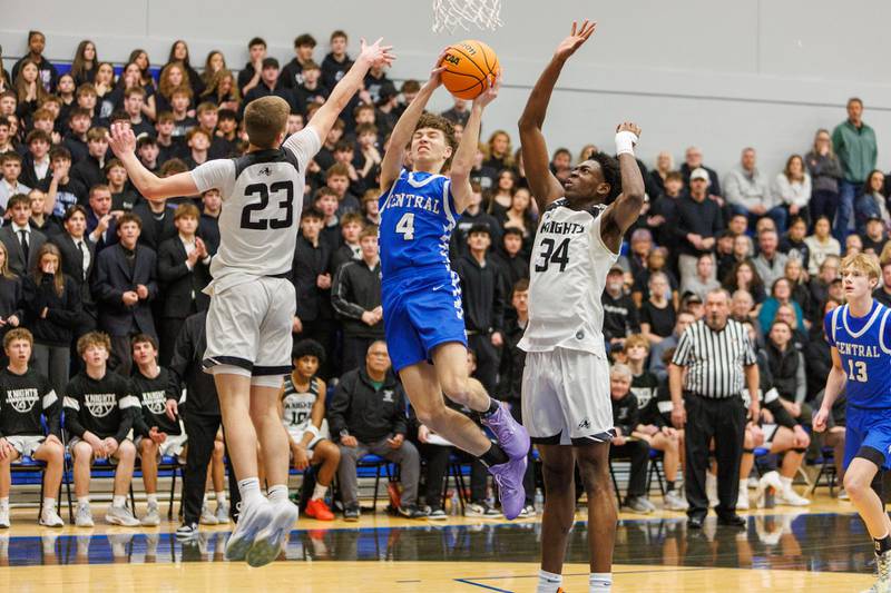 Burlington Central's Ryan Carpenter goes in for the shot splitting the defense of Kaneland's Connor Kimme (23) and Jeffery Hassan (34) at the Class 3A Burlington Central Regional Final on Friday, Feb. 27,2026 in Burlington.