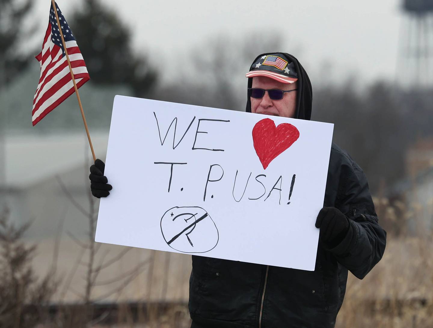 Ted McCarron holds a sign in support of Turning Point USA Thursday, Feb. 5, 2026, across the street from a group against Turning Point protesting in front of Genoa-Kingston High School. The gathering is protesting the “History Rocks” assembly which is part of a nationwide campaign by the U.S Department of Education tied to the nation’s 250th anniversary and organized by the high school’s Turning Point USA, Club America chapter, a nonprofit founded in 2012 by the late Charlie Kirk.