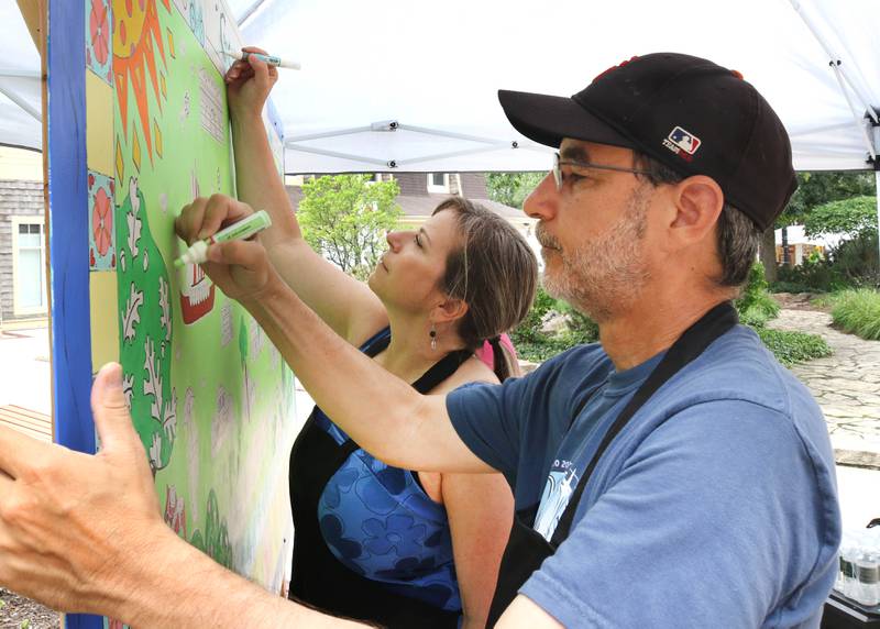 Sandy Kresler and Mike Litwin, both from Geneva, work on the Geneva Chamber of Commerce’s paint-by-number community art project Saturday, July 26, 2025, during at the Geneva Arts Fair on Third Street in Geneva.