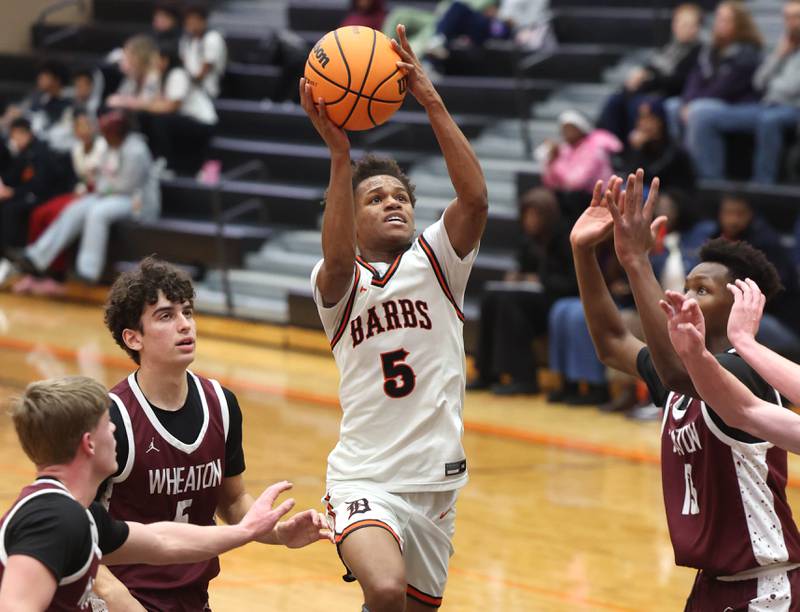 DeKalb's Bryan Miller drives the lane among three Wheaton Academy defenders during their game Wednesday, Jan. 14, 2026, at DeKalb High School.