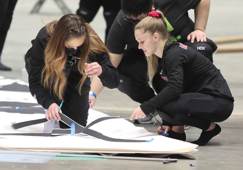 Northern Illinois University photography students work on a giant paper snowflake Tuesday, March 29, 2022, in the Convocation Center at NIU in DeKalb. The students are attempting to break the world record for the largest paper snowflake.