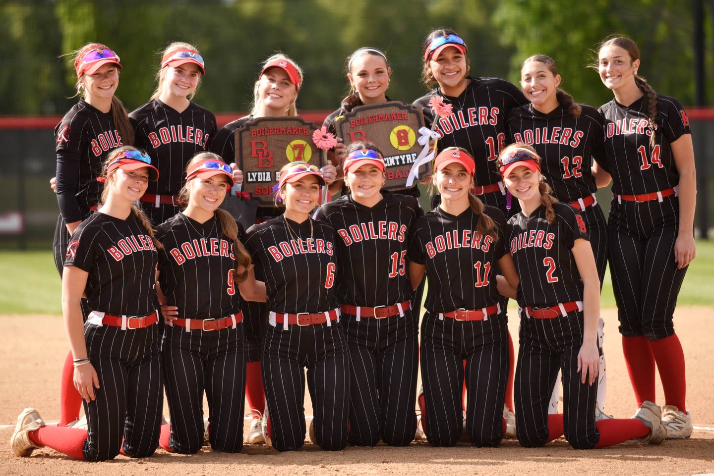 The Bradley-Bourbonnais softball team poses together after honoring the team's two seniors, Lydia Hammond, standing third from left, and Evi McIntyre, standing fourth from left, ahead of the Boilermakers' home game against Sandburg Wednesday, May 13, 2026.